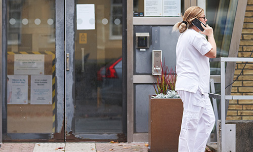 vårdpersonal utanför sjukhus pratar i telefon